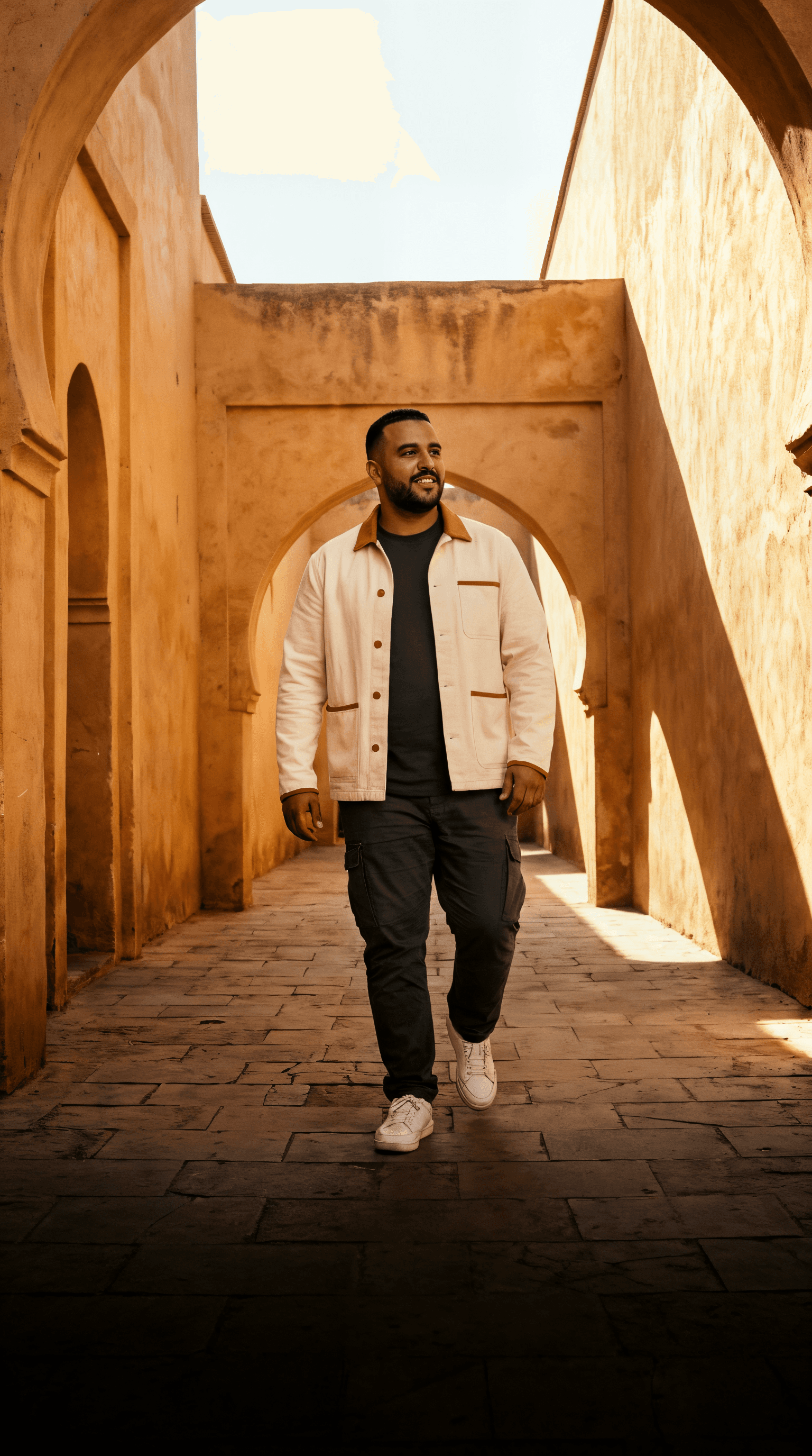 Homme en tenue urbaine contemporaine BADYSS, marchant dans une rue moderne au Maroc.